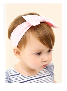 Détail d'un bandeau pour bébé rose doux avec un grand nœud sur un nouveau-né mannequin