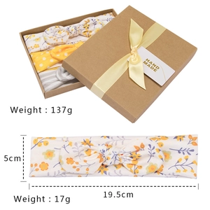 Detailed view of three cotton baby headbands in a gift box with handmade tag and measurements