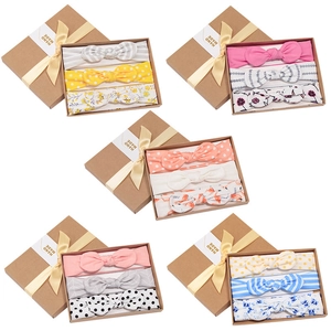 Pink baby headbands gift set with three bow styles in a kraft box and yellow ribbon