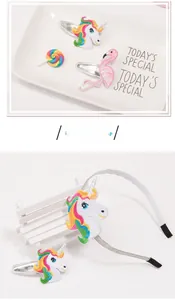 Dettaglio di accessori per capelli ricamati con unicorno e fenicottero su vassoio