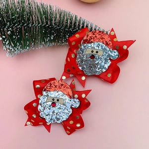 Dettaglio delle mollette per capelli a fiocco Babbo Natale con paillettes per bambini
