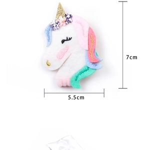 Detail view of unicorn hairband featuring felt flowers and gold glitter horn accessory