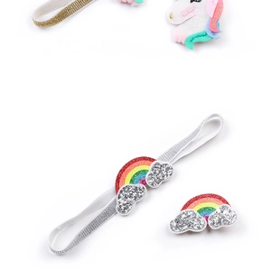 Close-up of baby unicorn headband set with glitter rainbow cloud accessories and clips