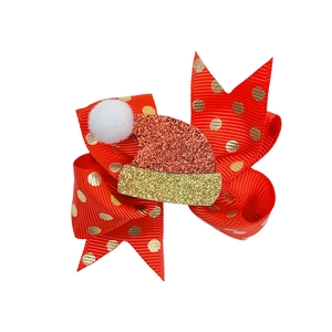Dettaglio del fiocco di Natale rosso con pois dorati e cappello luccicante