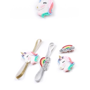 Detail of glitter unicorn and rainbow hair accessories set for kids on white background