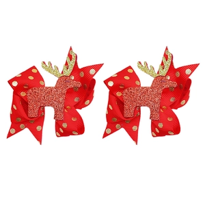 Dettaglio di fiocchi natalizi in nastro grosgrain rosso con pois dorati e motivi di renna