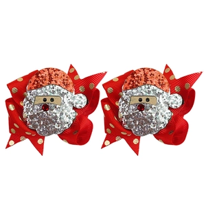 Dettaglio di fermagli per capelli a fiocco rosso con Babbo Natale e pois dorati