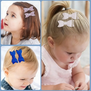 Three young girls wearing glitter and lychee grain leather bow hair clips in different colors