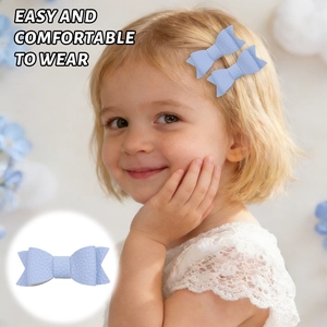 Close-up of a light blue lychee-grain leather bow hair clip on a young girl's head