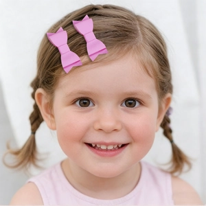 Pink glitter bow hair clips for girls in litchi textured faux leather close-up view