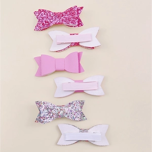 Detail view of 6-piece glitter bow hair clips showing front fabric and back ribbon-wrapped clips