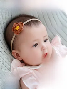 Detailed view of elastic seamless baby headband with brown crochet flower and bow