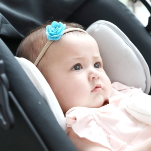 Close-up of baby girl wearing light blue felt flower headband with elastic nylon band