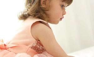 Detailed side view of apricot pink tulle dress featuring sequin bodice and bow waist detail