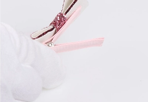 Detail showing pink glitter bow hair clip with fully fabric-wrapped crocodile metal clip
