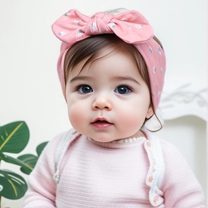 Détail d'un bandeau rose pour bébé avec motifs fraises porté par un jeune enfant
