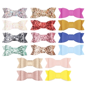 Detailed macro view of multi-colored glitter and litchi grain leather hair bow clips