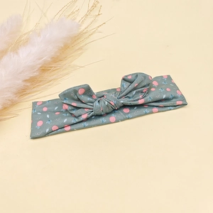 Détail d'un bandeau bébé vert à motif floral avec nœud oreilles de lapin en coton doux