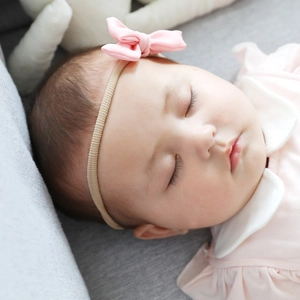 Close-up of soft pink linen bow headband on sleeping baby with high-elastic beige strap