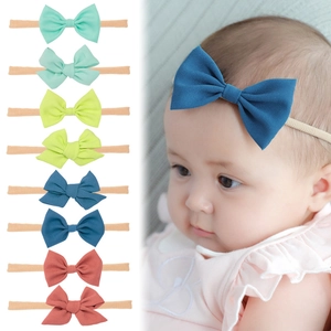 Set of 8 soft nylon baby headbands with large fabric bows in various colors for newborns