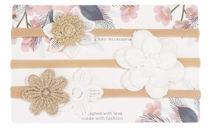 Detalle de tres diademas de nailon con flores de ganchillo para bebés en cartoncillo