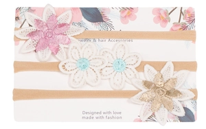 Detalle de tres diademas de encaje floral para bebés en una tarjeta decorativa