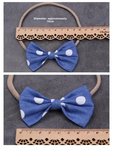 Blue polka dot bow hairband size measurement showing 10cm diameter on a wooden ruler