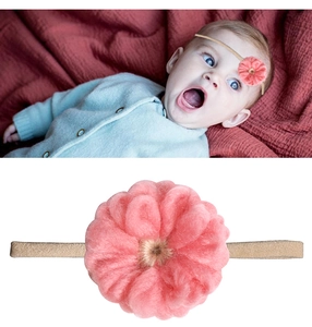 Dettaglio fascia neonato con fiore di peluche rosa e morbido cinturino in nylon
