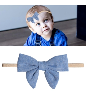 Dettaglio della fascia per neonati in nylon con fiocco blu in tessuto testurizzato