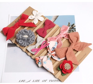 Detailed view of 10-piece baby headband set with bows and pearls on display card