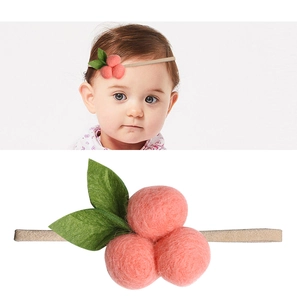 Detail eines elastischen Baby Stirnbandes mit drei rosa Filzkugeln und grünen Blättern