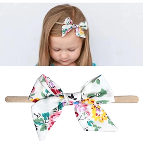 Détail d'un bandeau à fleurs pour bébés avec sangle élastique et nœud en tissu coton