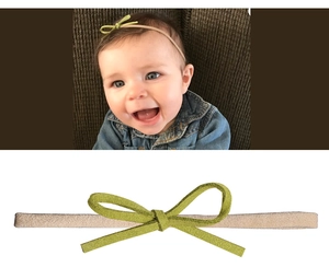 Makro-Detail von Baby-Schleifen-Stirnband mit grüner Wildlederschleife und Gummiband