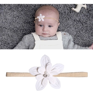 Detail of baby headband featuring multi-layer white fabric flower with pearl and rhinestone