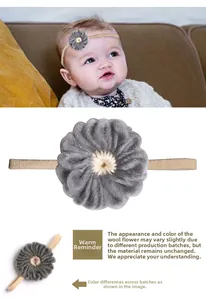Detail of baby headband featuring a grey knitted flower and high elastic skin-tone band