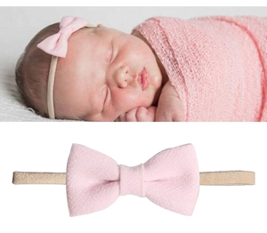Makro-Detail von Baby-Stirnbändern mit rosa Stoffschleifen und weichen Texturen