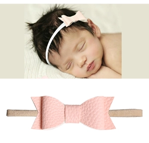 Nahaufnahme von Baby-Stirnband mit rosa Lederschleife und weichem, elastischem Band