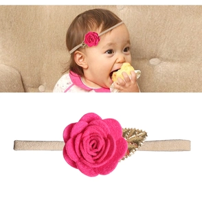 Nahaufnahme von Baby-Haarband mit pinkfarbener Rose, Goldblättern und Gummiband
