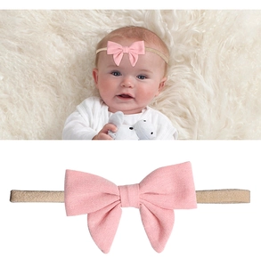 Detailaufnahme von Baby-Haarband mit großer rosa Leinenschleife und weichem Band