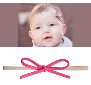 Close-up of baby headband with rose pink suede bow and nude elastic nylon band