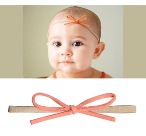 Detailansicht Baby Stirnband mit korallenrosa matt Schleife und weichem Nylonband