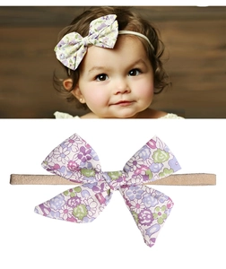 Detail eines Baby Stirnbandes mit rosa-lila Blumenbogen auf hochelastischem Band