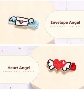 Detalle de bordado de alas de ángel y corazón en clips de pelo de felpa suave