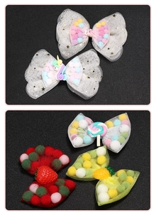 Detail of kids mesh bow hair clips with colorful pom-poms and cute unicorn resin charms