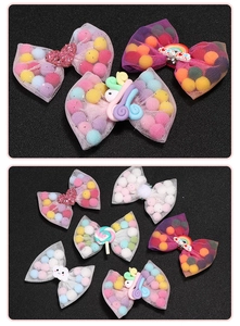 Detailed close-up of mesh bow hair clips with colorful plush balls and cartoon decorations