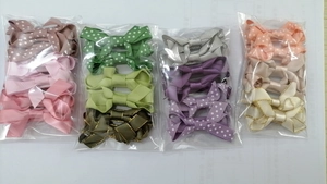 Detail of assorted grosgrain ribbon bow hair clips with polka dots in clear packaging