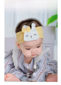 Detail of yellow elastic cotton baby headband with white plush bunny and yellow bow
