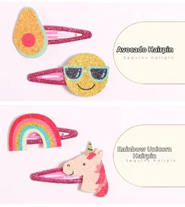 Detail von Glitzer-Haarspangen mit Motiven wie Avocado, Emoji-Gesicht, Regenbogen und Einhorn