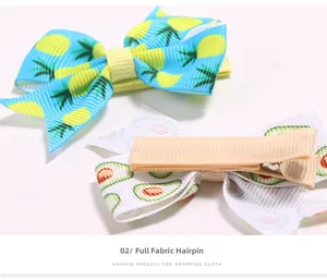 Détail de barrettes à cheveux gainées de tissu avec motifs ananas et avocat