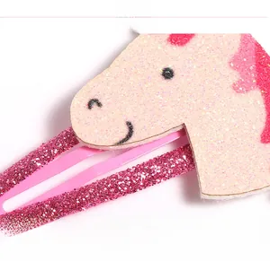 Makro-Detail einer rosa Glitzer-Einhorn-Haarspange mit funkelnder Textur und Metall-BB-Clip